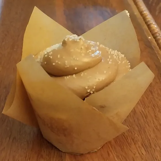 A Willow Bakery chocolate cupcake with chocolate buttercream in a kraft tulip case